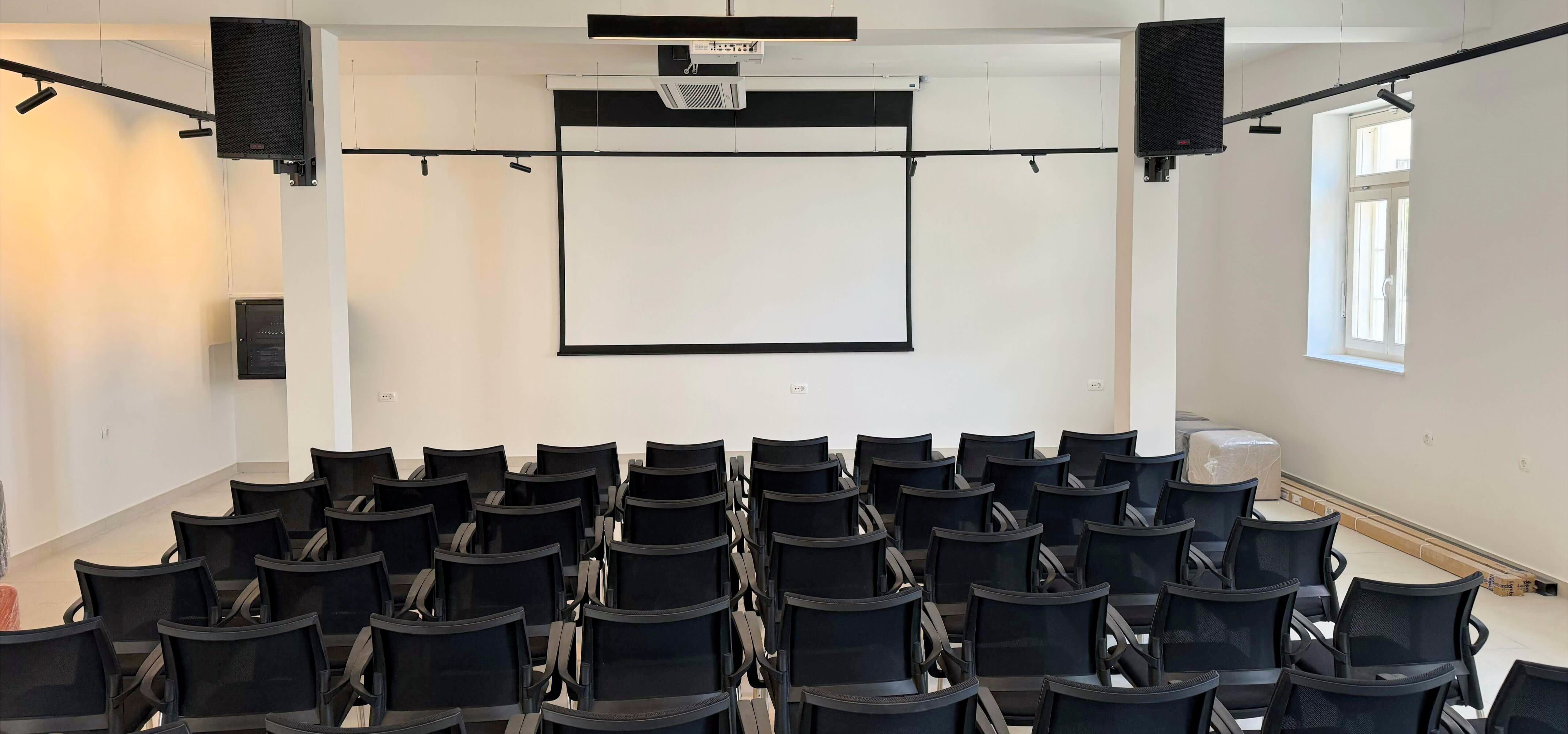 Projekcijsko platno s montiranim projektorom i profesionalnim ozvuenjem u multifunkcionalnom Centru za kulturu – kompletan AV sustav za prezentacije i dogaanja.