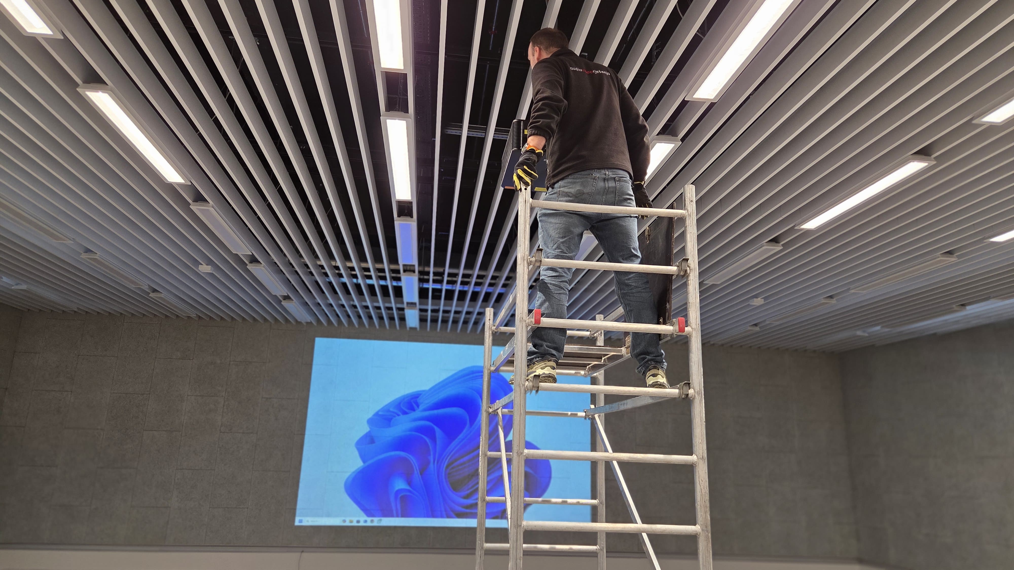 profesionalna monta�a laserskog projektora na skeli tijekom instalacije projekcijskog sustava