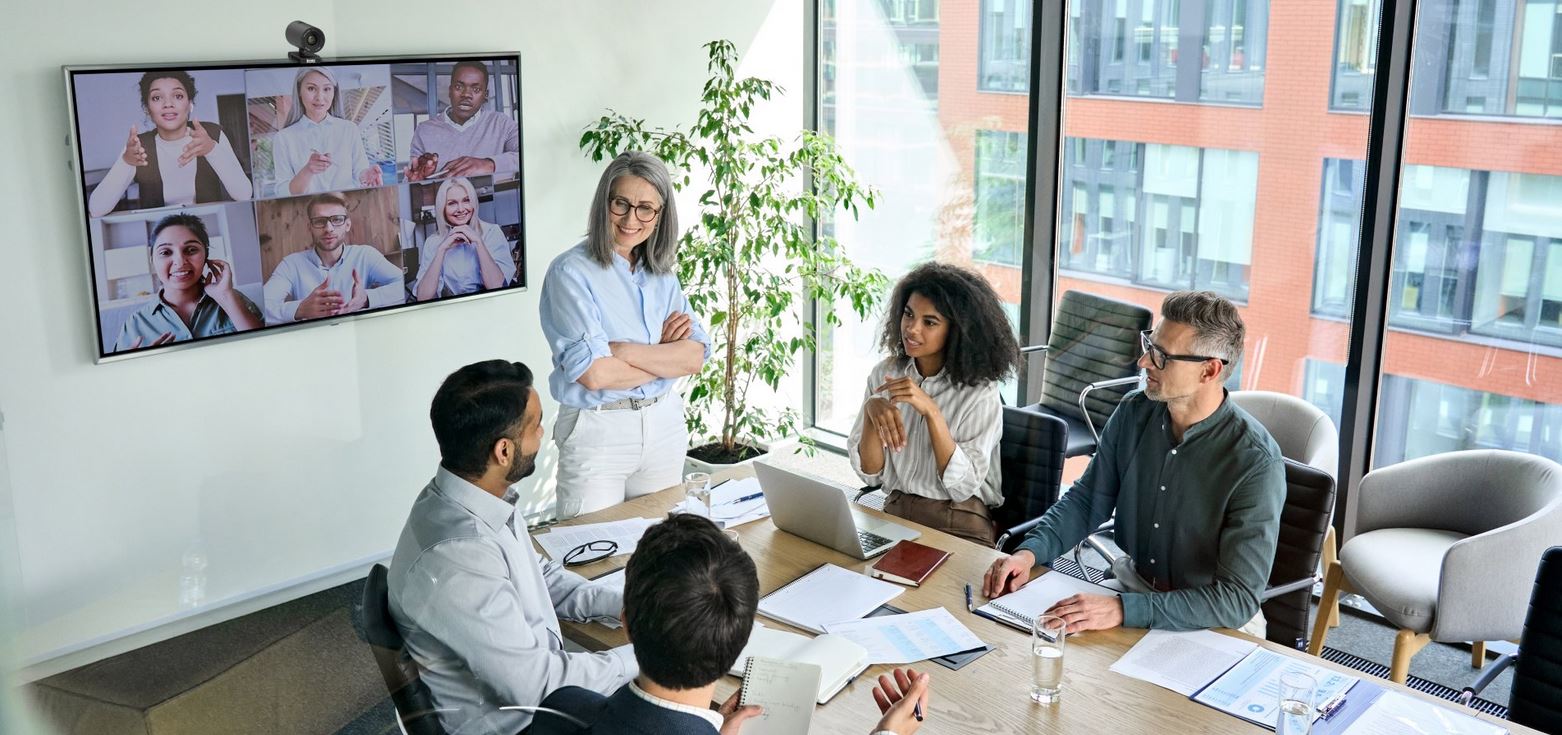 Poslovni tim u modernom uredu koristi sustav za videokonferenciju za sastanak na daljinu