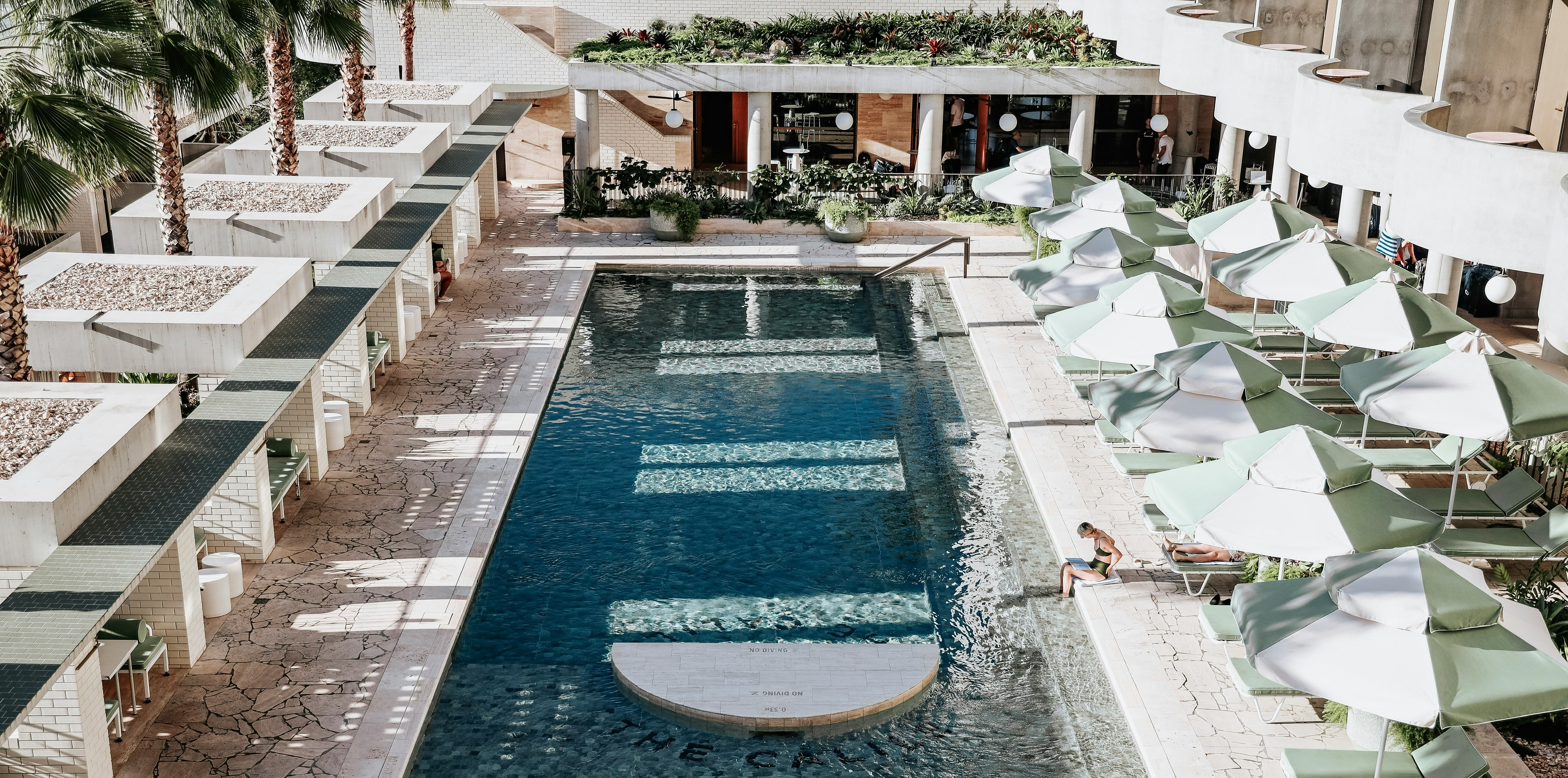 Vanjski bazen hotela s istom plavom vodom i prostorom za oputanje uz bazen